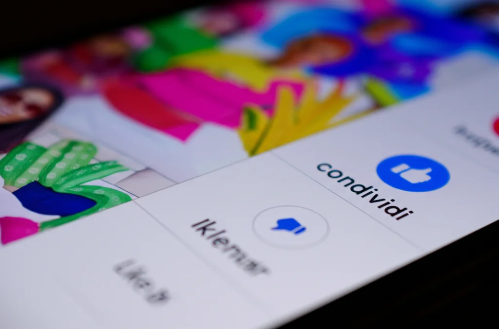 Primo piano di uno smartphone che mostra un feed social media vibrante con post di influencer, focus sui pulsanti 'like' e 'condividi', macro lens 85mm, illuminazione controllata e vivace, alta definizione, simboleggia le affordances di engagement e visibilità nell'influencer marketing.