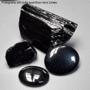Fotografia still life di giada quarzitica nera di Linwu, campioni grezzi e cabochon lucidati affiancati, obiettivo macro 90mm, alta definizione, illuminazione controllata per mostrare la texture fine e il colore nero intenso.