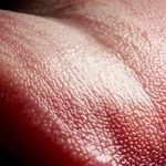 Macro fotografia dettagliata della superficie di una lingua umana, evidenziando la texture della patina e le papille gustative, lente macro 105mm, alta definizione, illuminazione diffusa per dettagli ottimali, concetto di diagnosi medica.