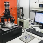 Immagine fotorealistica di un setup di diffrazione a raggi X (XRD) in un laboratorio di scienza dei materiali, con un fascio di raggi X focalizzato su un campione metallico. Obiettivo macro 85mm, illuminazione controllata, alta definizione per mostrare i dettagli della strumentazione e del campione, simboleggiando l'analisi precisa dei materiali.