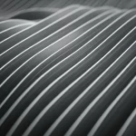 Un'immagine astratta che rappresenta una funzione bivariata con una dimensione periodica, visualizzata come una superficie ondulata che si estende su un piano. Wide-angle lens, 10-24mm, per catturare l'estensione della superficie, long exposure per dare un senso di fluidità alle onde periodiche, sharp focus sui dettagli della superficie.