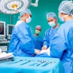 Un team chirurgico pediatrico in sala operatoria, concentrato durante un intervento di appendicectomia laparoscopica su un bambino. L'immagine mostra i chirurghi, gli infermieri, i monitor con immagini laparoscopiche e l'attrezzatura sterile. Obiettivo prime, 35mm, illuminazione controllata da sala operatoria, profondità di campo per evidenziare il team.