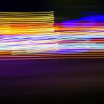 Un'immagine astratta e dinamica che rappresenta il concetto di percezione visiva ad alta velocità, con linee di luce sfocate che suggeriscono il movimento rapido degli occhi e degli stimoli visivi. Telephoto zoom, 200mm, fast shutter speed, motion blur, colori vivaci e contrastati.