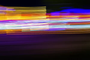 Un'immagine astratta e dinamica che rappresenta il concetto di percezione visiva ad alta velocità, con linee di luce sfocate che suggeriscono il movimento rapido degli occhi e degli stimoli visivi. Telephoto zoom, 200mm, fast shutter speed, motion blur, colori vivaci e contrastati.