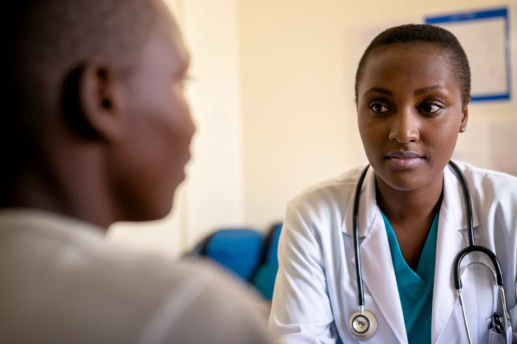 A healthcare provider in Kenya interacting with a young person living with HIV, 35mm portrait, depth of field, focus on connection, clinic setting, soft natural light.