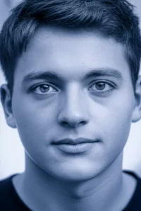 Ritratto fotorealistico di uno studente universitario che guarda direttamente la telecamera, trasmettendo un mix di determinazione e vulnerabilità, lenti prime da 35 mm, profondità di campo superficiale, luce naturale, blu duotone e grigio.