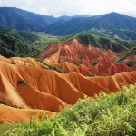 Veduta aerea di un paesaggio di calanchi estesi in Taiwan, con creste affilate e profonde incisioni che evidenziano l'erosione rapida. Obiettivo zoom 35mm, luce diffusa per dettaglio uniforme, alta risoluzione per texture del terreno, evidenziando l'impatto dell'attività tettonica.