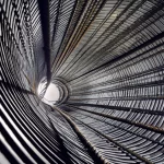 Immagine concettuale di un pozzo sotterraneo in calcestruzzo rinforzato con acciaio, con linee di forza che illustrano l'impatto di un'esplosione laterale. Dettaglio macro sulle texture dei materiali, illuminazione drammatica, obiettivo 50mm prime, profondità di campo.