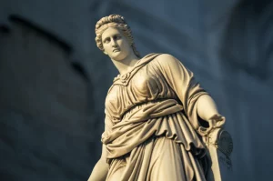 Un'immagine concettuale fotorealistica che rappresenta la fine o la crisi del conservatorismo: una vecchia statua classica (simbolo di tradizione) che inizia a sgretolarsi leggermente, vista con un obiettivo grandangolare 24mm, con una luce crepuscolare che suggerisce incertezza sul futuro, profondità di campo.