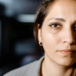 A thoughtful portrait of a person, representing introspection and narrative identity, captured with a 35mm lens, featuring depth of field to isolate the subject.
