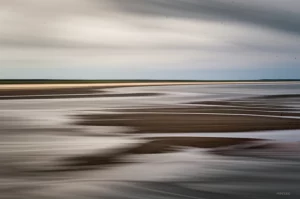 Veduta aerea grandangolare, 10mm, della Baia di Sylt-Rømø con l'alta marea che inonda parzialmente le piane tidali, mettendo in evidenza l'interazione tra terra e mare sotto un cielo nuvoloso drammatico, long exposure per acqua setosa, sharp focus sull'orizzonte.