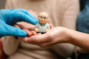 Immagine concettuale che rappresenta l'integrazione socio-sanitaria: due mani, una simboleggiante l'assistenza sanitaria con un guanto medico e l'altra l'assistenza sociale con abbigliamento informale, che si uniscono per sostenere una figura stilizzata di un anziano sorridente. Sfondo neutro e luminoso, lenti prime 35mm, profondità di campo, colori caldi e rassicuranti.