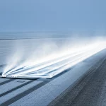 Una visualizzazione concettuale di una pista di atterraggio in una regione di permafrost, con un sistema di ventilazione sotterraneo evidenziato che emette aria fredda stilizzata. Fotografia paesaggistica, obiettivo grandangolare 24mm, effetto profondità di campo, colori freddi dominanti come blu e grigio, atmosfera invernale.