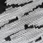Fotografia macro di cristalli bianchi di LiAl-LDH su una superficie scura da laboratorio, illuminazione controllata per evidenziare la struttura stratificata, obiettivo macro 100mm, alta definizione, messa a fuoco precisa.
