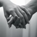 Un'immagine simbolica che rappresenta la speranza e il miglioramento della qualità della vita dopo un trattamento oncologico. Potrebbe essere una mano che ne stringe un'altra con delicatezza in un ambiente medico sereno, o un paziente che sorride guardando fuori da una finestra. Obiettivo prime 50mm, luce soffusa, profondità di campo, colori tenui per un effetto emotivo e rassicurante, bianco e nero film.