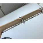 Immagine dettagliata di un chiodo intramidollare inserito in un modello di omero, con focus sulle viti di bloccaggio distali. Obiettivo macro 100mm, alta definizione, illuminazione da studio per enfatizzare la precisione chirurgica e i dettagli metallici del chiodo e delle viti contro la struttura ossea sintetica.