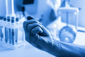 Una mano forte e curata, simbolo di salute e vitalità, con sullo sfondo sfocato elementi che richiamano la ricerca medica e il benessere, 35mm portrait, duotone blu e grigio, profondità di campo.
