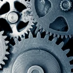 Wide-angle, 24mm, depth of field photograph showing a complex system of interlocking gears, some moving smoothly, others appearing stuck or grinding, representing the interaction and potential friction between monetary and fiscal policies.