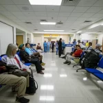Wide-angle lens, 24mm, sharp focus, depicting a busy hospital emergency department waiting area with diverse people, hinting at the volume of patients seeking care.