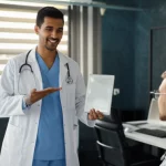 Un medico sorridente mostra a un paziente i risultati positivi di una terapia su un tablet, in un moderno studio medico. Obiettivo prime 35mm, luce naturale, atmosfera positiva e rassicurante, profondità di campo.