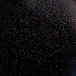Immagine concettuale di particelle colorate che si muovono rapidamente lungo percorsi circolari interconnessi su uno sfondo scuro, rappresentando un processo zero-range su un toro discreto. Wide-angle lens, 15mm, long exposure per creare scie luminose di movimento, sharp focus sulle particelle, alta saturazione dei colori.