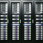 Moderno data center con server visibili, alcuni dei quali utilizzano sistemi di raffreddamento a liquido avanzati come piastre fredde o immersione, simboleggiando l'innovazione sostenibile guidata dall'LCA. Illuminazione controllata, focus nitido sui dettagli tecnologici, obiettivo macro 85mm.