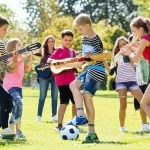 Gruppo eterogeneo di adolescenti (9-14 anni) che partecipano a diverse attività sportive ed extrascolastiche (calcio, musica, danza) in un parco soleggiato. Fotografia di gruppo, obiettivo zoom 35mm, colori vivaci, profondità di campo media per mostrare sia i ragazzi che lo sfondo.