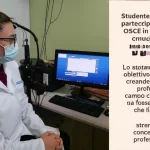 Studente di audiologia partecipa a un esame OSCE in un ambiente clinico simulato e ben illuminato. Lo studente interagisce con un paziente simulato seduto di fronte a un audiometro. La scena è catturata con un obiettivo prime 35mm, creando una leggera profondità di campo che mantiene a fuoco sia lo studente che il paziente, trasmettendo concentrazione e professionalità.