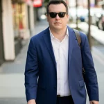 Portrait of a visually impaired person navigating a busy street using an assistive device, 35mm portrait, depth of field, natural lighting.