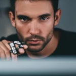 A photorealistic portrait, 35mm lens, depth of field, showing a person concentrating intently while performing a motor skill task on a computer screen, with finger sensors visible.