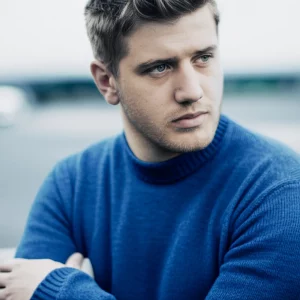 A thoughtful man looking into the distance, 35mm portrait, depth of field, blue and grey duotones, representing reflection on health and fertility.