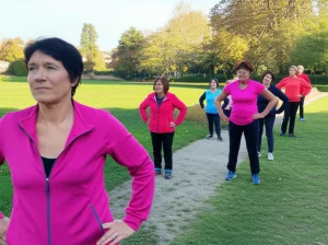 Un gruppo eterogeneo di anziani attivi che partecipano a una sessione di ginnastica dolce all'aperto, alcuni indossano discretamente dei giubbotti zavorrati sotto i vestiti sportivi. Scatto con obiettivo da 50mm, luce dorata del tardo pomeriggio, effetto bokeh sullo sfondo per enfatizzare i soggetti.