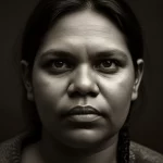 Un ritratto toccante di una donna indigena australiana, 35mm, con un'espressione che riflette sia la forza che il peso delle sfide legate alla salute mentale, duotone seppia e grigio, profondità di campo.