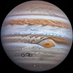 Immagine astronomica fotorealistica di Giove che mostra le sue spettacolari e dinamiche aurore infrarosse ai poli, catturate con dettagli senza precedenti dal telescopio James Webb. Obiettivo grandangolare, focale 10mm, lunga esposizione per evidenziare i deboli segnali aurorali, messa a fuoco nitida sulle strutture atmosferiche e aurorali, con la Grande Macchia Rossa e le bande nuvolose del pianeta visibili sullo sfondo, enfatizzando l'emissione di H₃⁺.