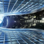 Visualizzazione fotorealistica dell'interno del dispositivo Heliotron J, con le complesse bobine magnetiche che avvolgono la camera toroidale dove il plasma viene confinato. Luce ambientale soffusa che evidenzia i dettagli metallici e tecnologici. Obiettivo grandangolare 16mm, messa a fuoco nitida su tutta la scena, lunga esposizione per catturare la stabilità della struttura.