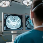 Un chirurgo osserva attentamente una scansione PET/CT della colonna vertebrale su un monitor ad alta risoluzione in una sala operatoria moderna e illuminata. Prime lens, 35mm, profondità di campo per mettere a fuoco il monitor e il chirurgo, atmosfera di concentrazione e tecnologia avanzata.