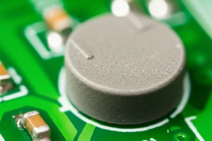 Immagine fotorealistica di un varistore a disco a base di ZnO montato su un circuito stampato, obiettivo macro 85mm, alta definizione, illuminazione da studio controllata, che evidenzia la ceramica policristallina e i contatti argentati lucidi.