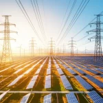 Wide-angle landscape photo showing a vast network of high-voltage transmission lines spanning continents, with solar farms in sunny regions and wind turbines in windy areas, symbolizing global energy interconnection. 10mm wide-angle lens, long exposure.