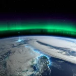 Immagine fotorealistica della ionosfera terrestre sopra l'India durante la super tempesta geomagnetica del 17 marzo 2015, che mostra enigmatiche macchie di plasma luminose (blob) invece delle previste bolle. Vista dallo spazio, con la curvatura della Terra e l'aurora boreale visibile in lontananza. Astronomical, wide-angle, 10-24mm, long exposure times, sharp focus.