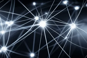 Immagine astratta e tecnologica che rappresenta una rete neurale complessa con nodi luminosi e connessioni. Alcune connessioni sono interrotte o sbiadite per simboleggiare dati incompleti, mentre un meccanismo di 'attenzione' (magari un fascio di luce focalizzato) evidenzia selettivamente alcune parti della rete. Prime lens, 35mm, depth of field, film noir style con forti contrasti e ombre per un'atmosfera high-tech e misteriosa.