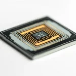 Photorealistic still life image of a compact, futuristic optical biosensor chip on a white background, highlighting its intricate micro-structure and suggesting advanced medical technology. Use macro lens, 100mm, high detail, precise focusing, controlled lighting.