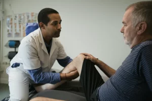 A physical therapist assisting an elderly patient with knee rehabilitation exercises, 35mm portrait, depth of field.