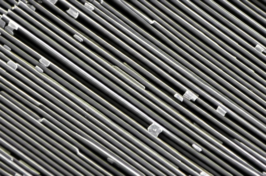 Macro fotografia, obiettivo 90mm, di nanobarre d'argento su un substrato di silicio, illuminazione controllata per evidenziare la struttura tridimensionale e i dettagli delle nanostrutture. Focus preciso sulle singole barre.