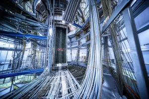 Visualizzazione artistica dell'esperimento GERDA nei Laboratori Nazionali del Gran Sasso, con i rivelatori di germanio immersi in un criostato di argon liquido. L'immagine mostra la complessità dell'apparato, con cavi e strutture di supporto. Obiettivo grandangolare 10mm, lunga esposizione per catturare i dettagli, focus nitido sull'array di rivelatori, atmosfera high-tech con luci soffuse blu e bianche.