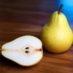 Fotografia still life di pere mature su un tavolo di legno rustico, una delle quali è sezionata per mostrare la polpa. Una luce blu direzionale illumina parzialmente la scena, creando un'atmosfera misteriosa e scientifica. Obiettivo macro 60mm, alta definizione, illuminazione controllata, focus preciso sulla texture della pera.