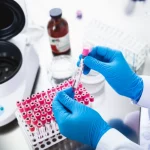 Un veterinario in un laboratorio moderno analizza campioni di sangue canino per la preparazione di PRP, con provette e una centrifuga visibili sullo sfondo. Macro lens, 60mm, high detail, controlled lighting, atmosfera professionale e pulita.