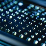 Immagine macro fotorealistica di una piattaforma microfluidica digitale magnetica, con goccioline luminose che si muovono con precisione su una superficie superidrofobica scura, illuminazione da studio per dettagli nitidi e riflessi, obiettivo macro 60mm, che evoca alta tecnologia e innovazione scientifica.
