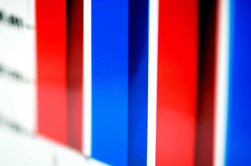 Visualizzazione di un grafico a barre astratto con colori rosso e blu che rappresentano i due gruppi di trattamento (controllo del ritmo vs controllo della frequenza) e barre di altezza simile a simboleggiare la mortalità, con un focus selettivo su una barra, obiettivo 50mm, profondità di campo.