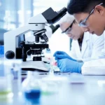 Photorealistic image of researchers working in a bright, modern lab, focusing on microscopic samples, macro lens, 60mm, high detail, controlled lighting.
