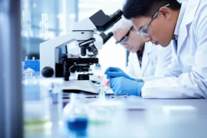 Photorealistic image of researchers working in a bright, modern lab, focusing on microscopic samples, macro lens, 60mm, high detail, controlled lighting.